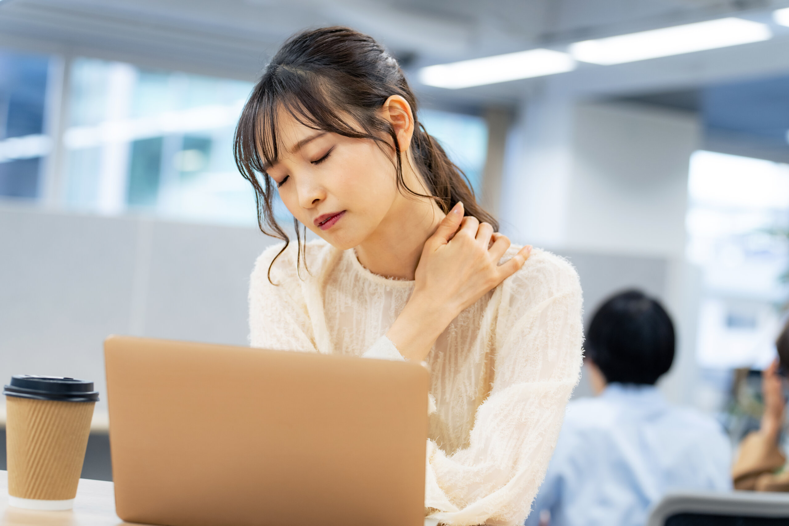 職場で肩こりを感じる女性